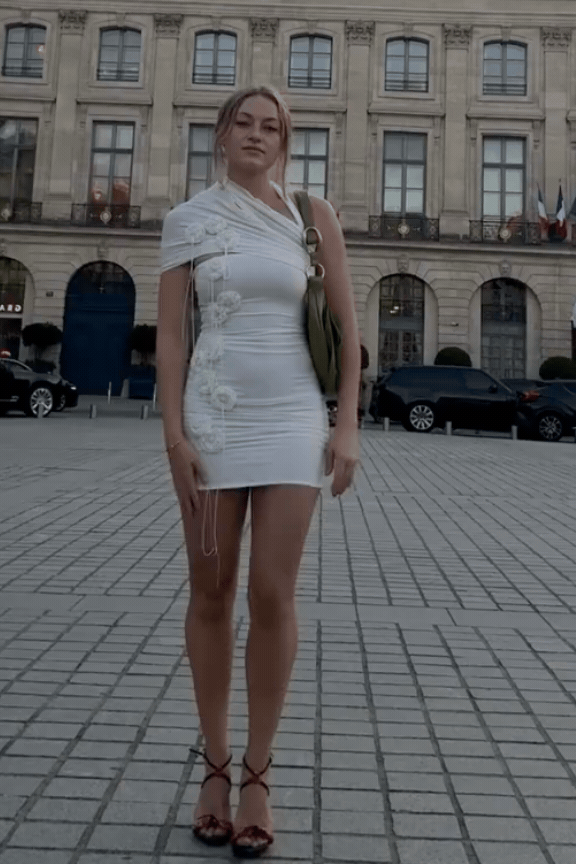 Freja wears a white dress standing in Paris